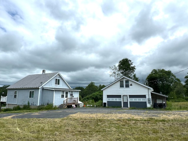 view of front of home with a garage and an outdoor structure