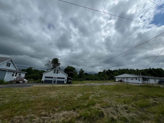 view of yard with a garage and an outbuilding