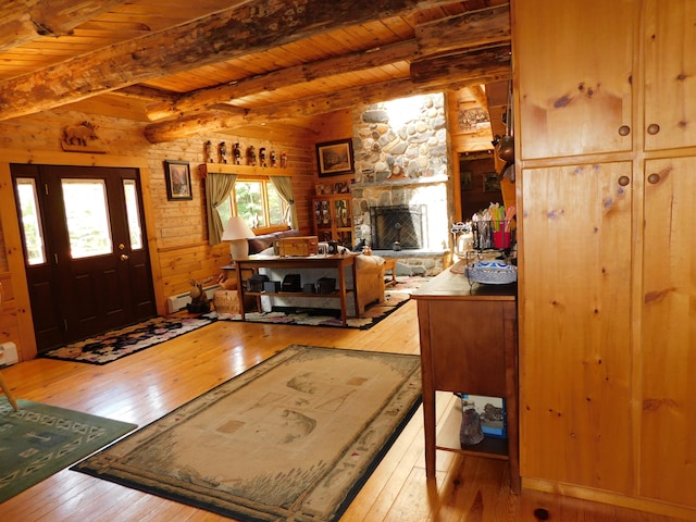 living room featuring a stone fireplace, wood ceiling, and light hardwood / wood-style floors