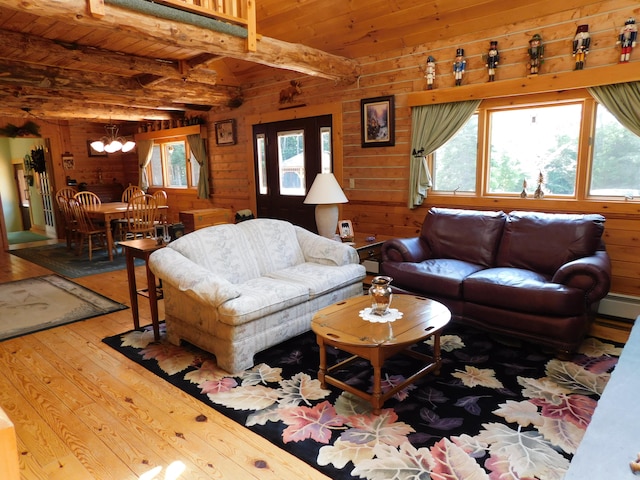 living room featuring wood walls, wood-type flooring, beamed ceiling, and a healthy amount of sunlight