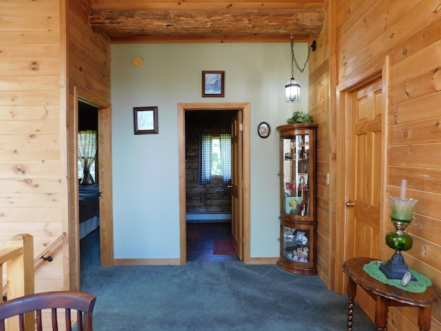 hall with wood walls, beamed ceiling, and carpet flooring