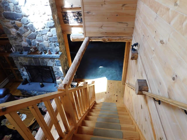 61 Sawyer Pond Highlands, Greenville, ME 04441 - stairway featuring wood walls, a stone fireplace, and wood finished floors