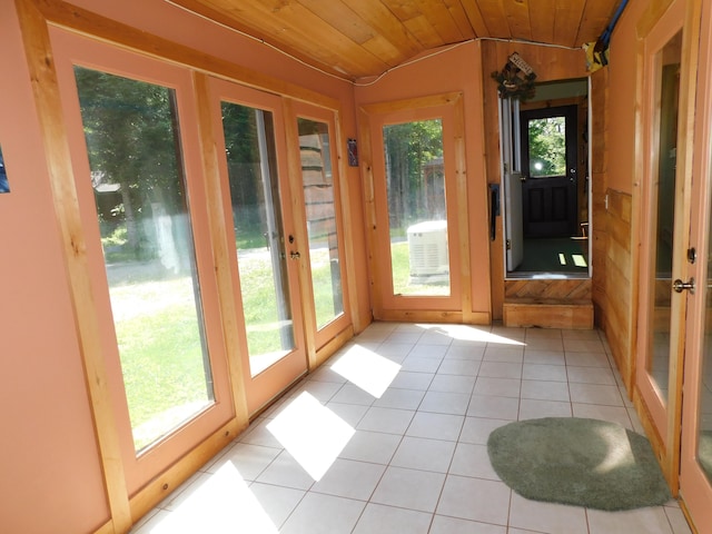 unfurnished sunroom featuring french doors, wood ceiling, vaulted ceiling, and a wealth of natural light