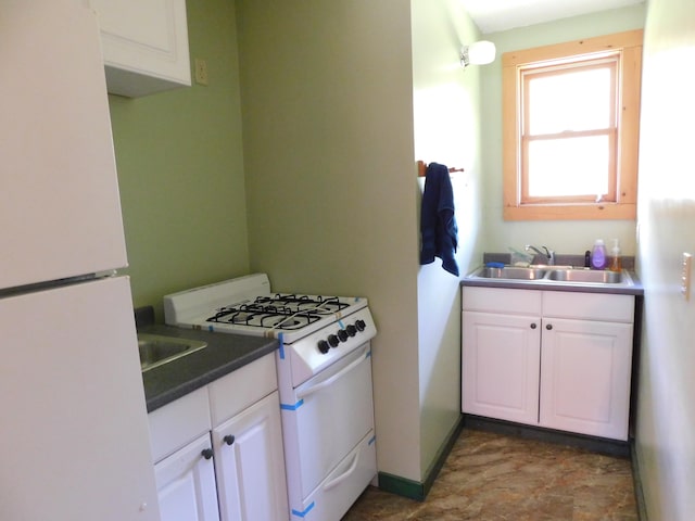 kitchen with tile patterned floors, white appliances, sink, and white cabinetry