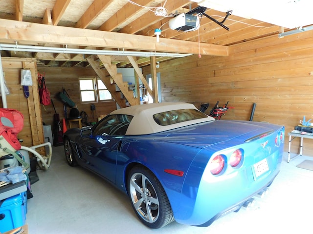 garage with a garage door opener and wooden walls