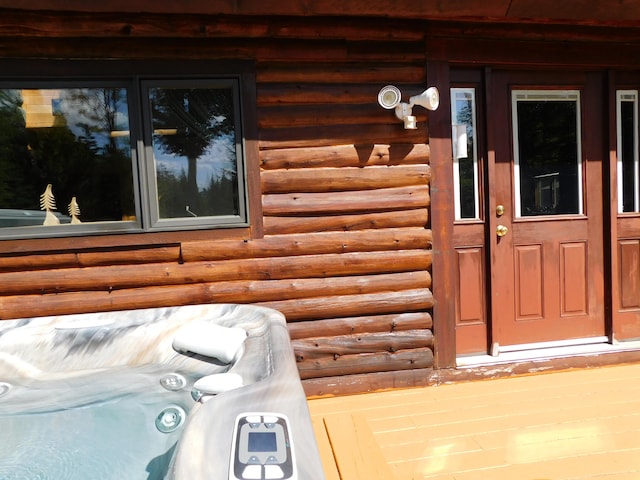 property entrance with an outdoor hot tub