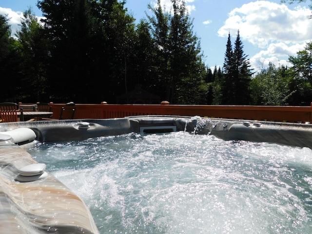 view of swimming pool with a hot tub