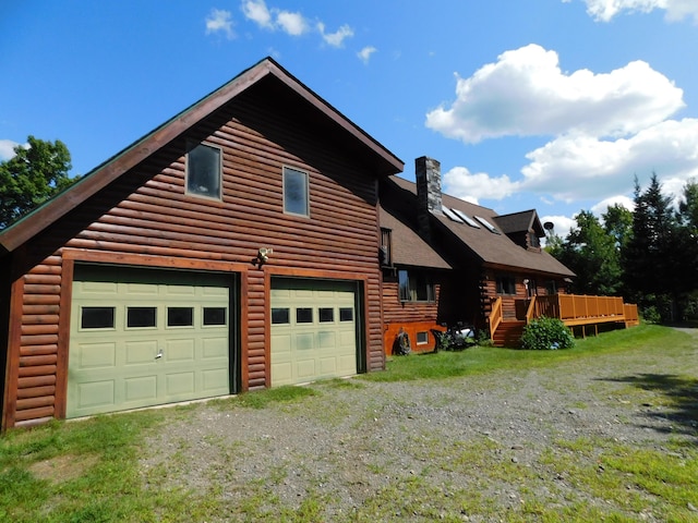61 Sawyer Pond Highlands, Greenville, ME 04441 - exterior space with driveway, a wooden deck, a chimney, and a garage