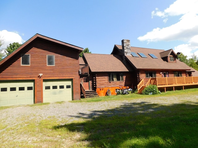 view of front of property with a garage, a front lawn, and a wooden deck