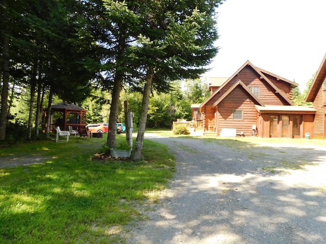 log-style house featuring a front lawn and a gazebo