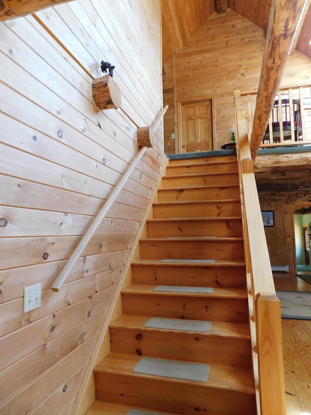 stairway featuring wood walls, high vaulted ceiling, and wooden ceiling