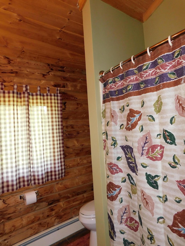 bathroom featuring baseboard heating, wooden walls, wood ceiling, and toilet