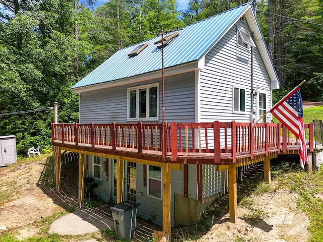 rear view of house featuring a wooden deck