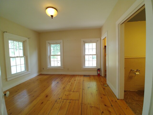 interior space featuring light wood-type flooring and tile walls