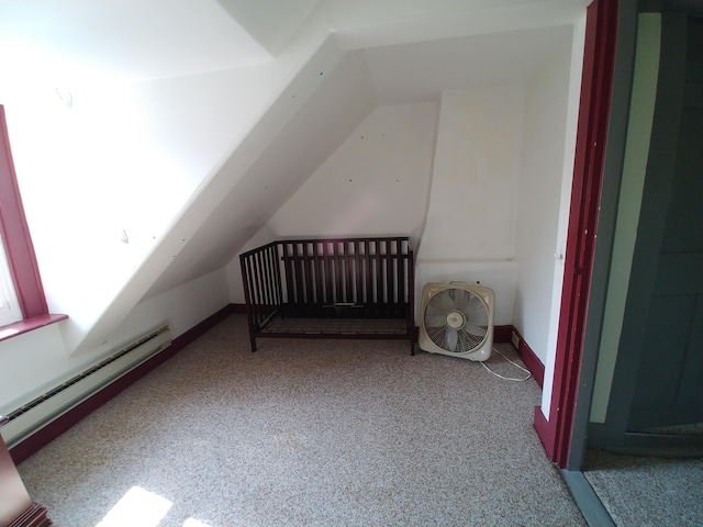 additional living space with carpet floors, baseboard heating, and vaulted ceiling