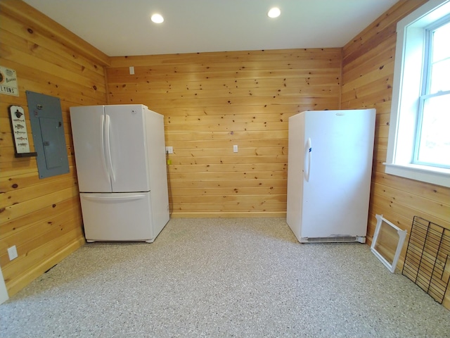 clothes washing area featuring wood walls and electric panel