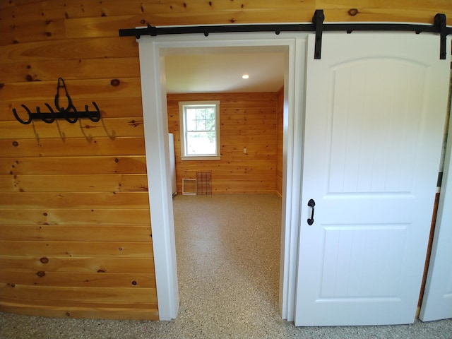 corridor with wooden walls and a barn door