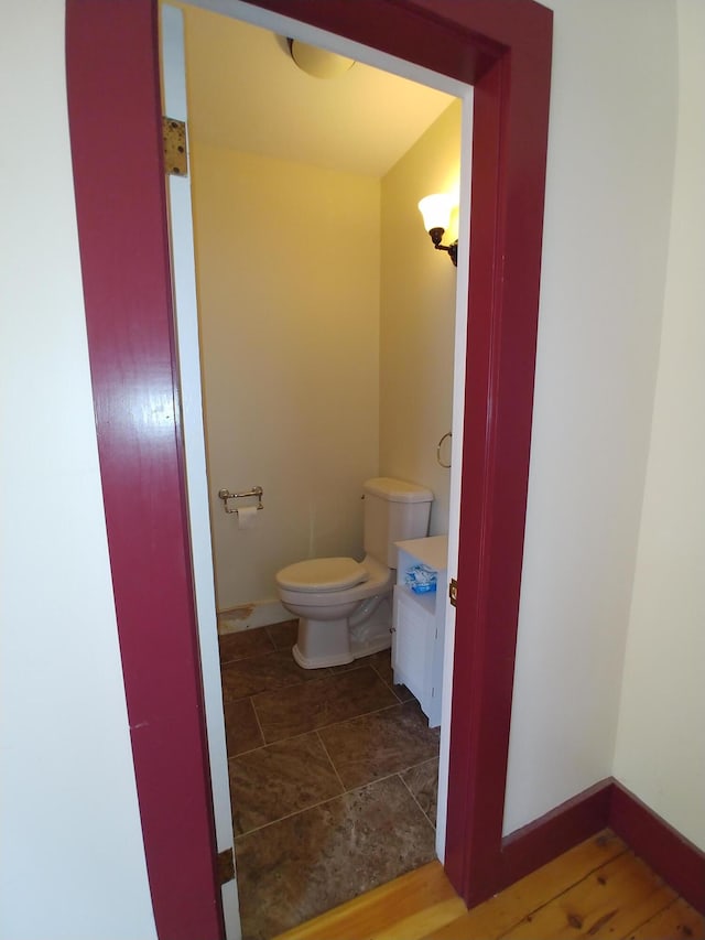 bathroom featuring wood-type flooring and toilet