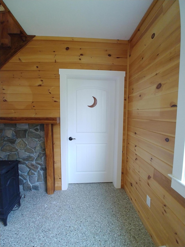 interior space featuring a wood stove and wood walls