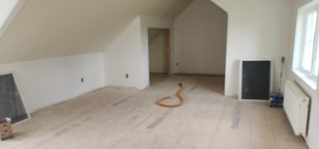 bonus room featuring radiator and vaulted ceiling