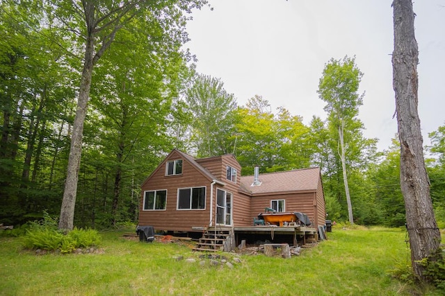 back of house featuring a deck and a lawn