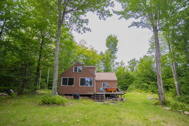 back of property with a yard and a deck