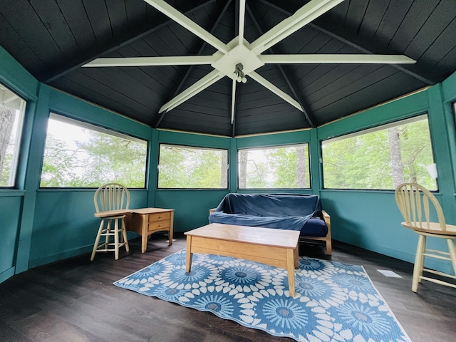 sunroom with a healthy amount of sunlight and vaulted ceiling with beams