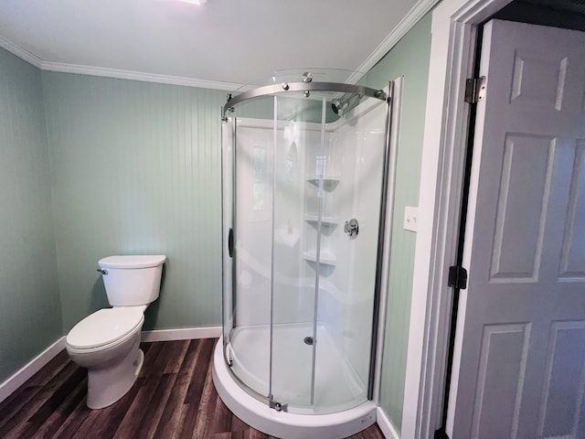 bathroom with wood-type flooring, ornamental molding, toilet, and a shower with shower door