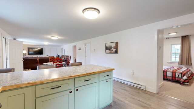 kitchen with baseboard heating and light carpet