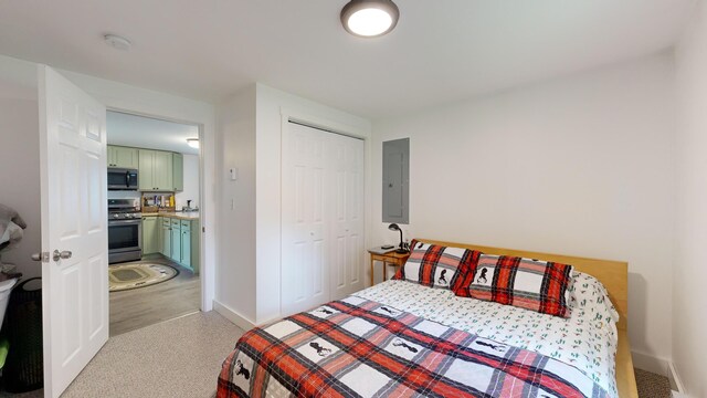 bedroom with a closet, electric panel, and light hardwood / wood-style floors