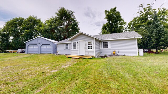 back of house featuring an outdoor structure, a garage, and a lawn