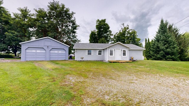 view of front of house with a garage, an outdoor structure, and a front yard