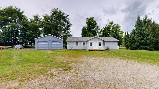 ranch-style house featuring a garage, a front yard, and an outbuilding