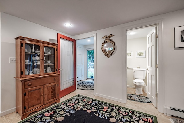 foyer entrance with light hardwood / wood-style flooring and a baseboard radiator