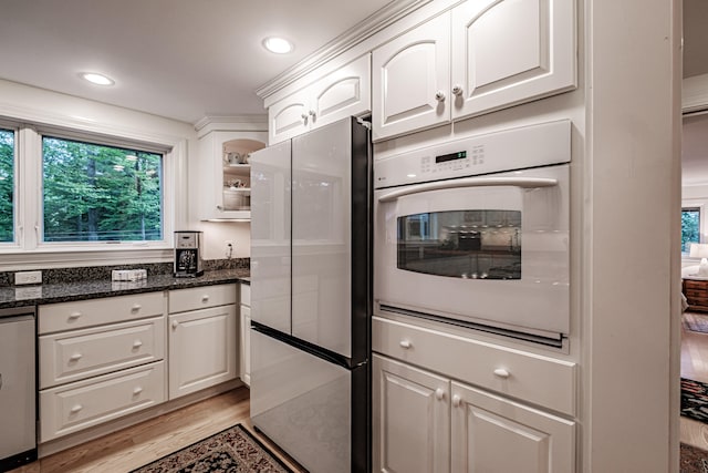 kitchen with stainless steel fridge, oven, a wealth of natural light, and light wood-type flooring