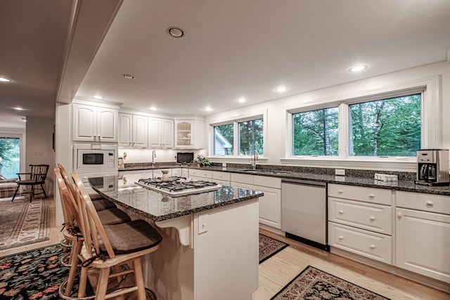 kitchen with appliances with stainless steel finishes, a healthy amount of sunlight, and light wood-type flooring