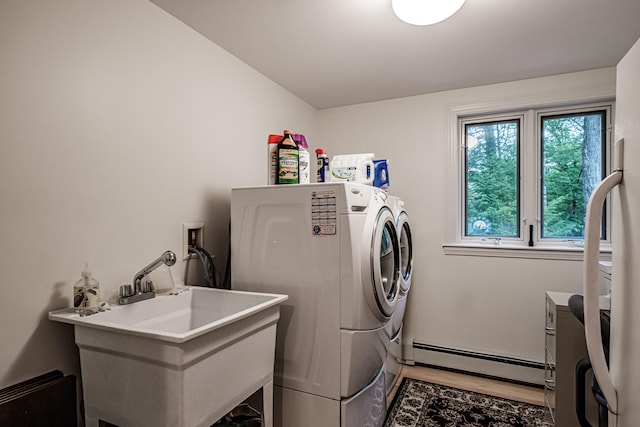 laundry room featuring a baseboard radiator, sink, light wood-type flooring, and separate washer and dryer