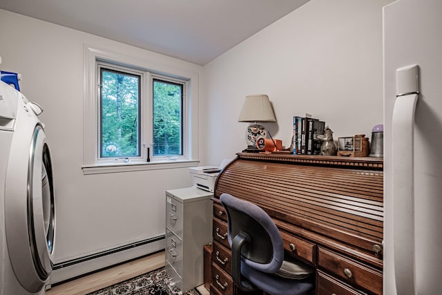 office space with washer / dryer, light wood-type flooring, a baseboard heating unit, and a healthy amount of sunlight