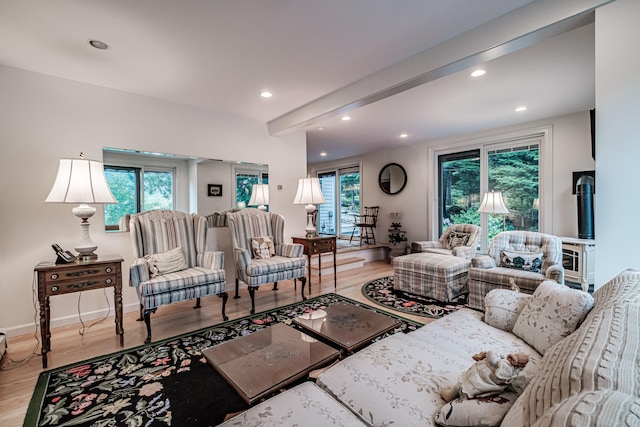 living room featuring beamed ceiling and light hardwood / wood-style flooring