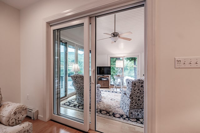 doorway to outside with light hardwood / wood-style floors, a baseboard radiator, and ceiling fan