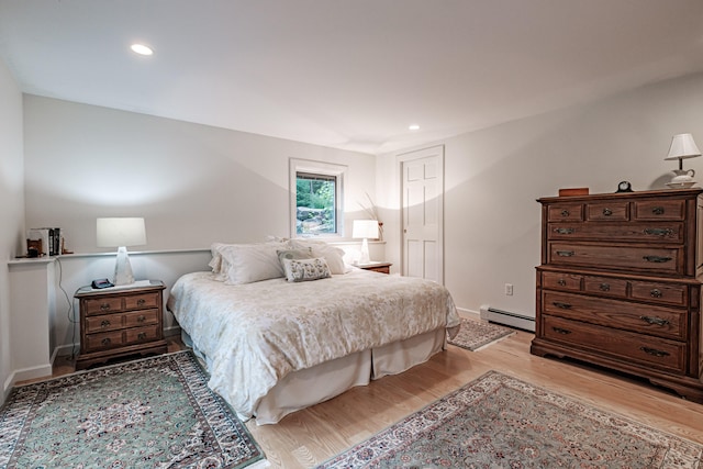 bedroom featuring light wood-type flooring and baseboard heating