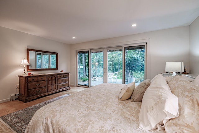 bedroom featuring access to outside, light wood-type flooring, and a baseboard heating unit