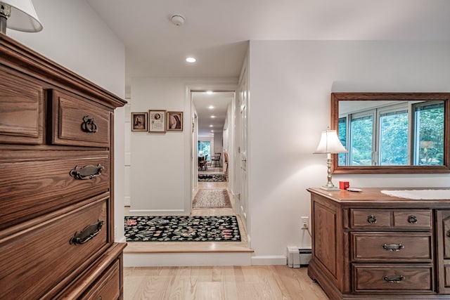 hallway with light hardwood / wood-style flooring and a baseboard radiator