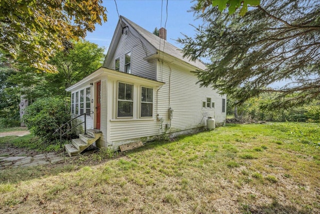 view of side of home with a yard