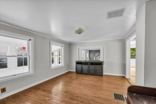 living room featuring light wood-type flooring and crown molding