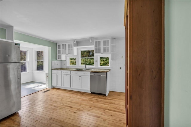 kitchen with white cabinets, stainless steel appliances, light wood-type flooring, and sink