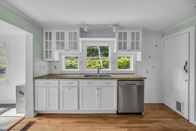 kitchen with light hardwood / wood-style floors, white cabinets, a healthy amount of sunlight, stainless steel dishwasher, and sink