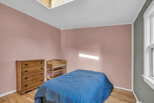 bedroom featuring light wood-type flooring and ornamental molding