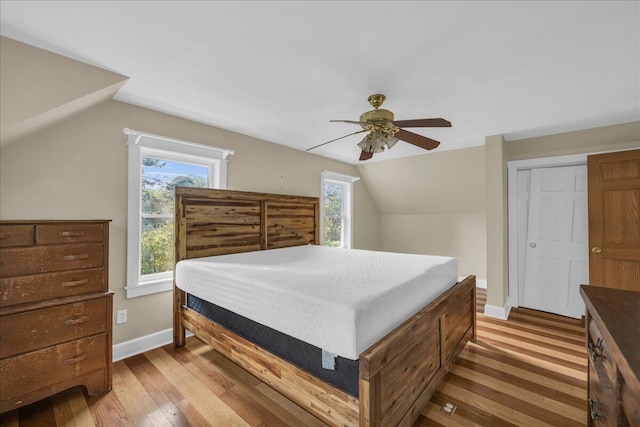 bedroom featuring lofted ceiling, hardwood / wood-style floors, ceiling fan, and a closet