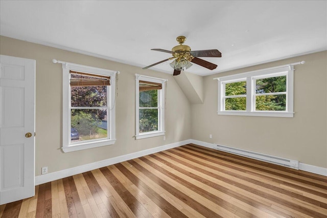 bonus room featuring light hardwood / wood-style flooring, a wealth of natural light, ceiling fan, and a baseboard heating unit